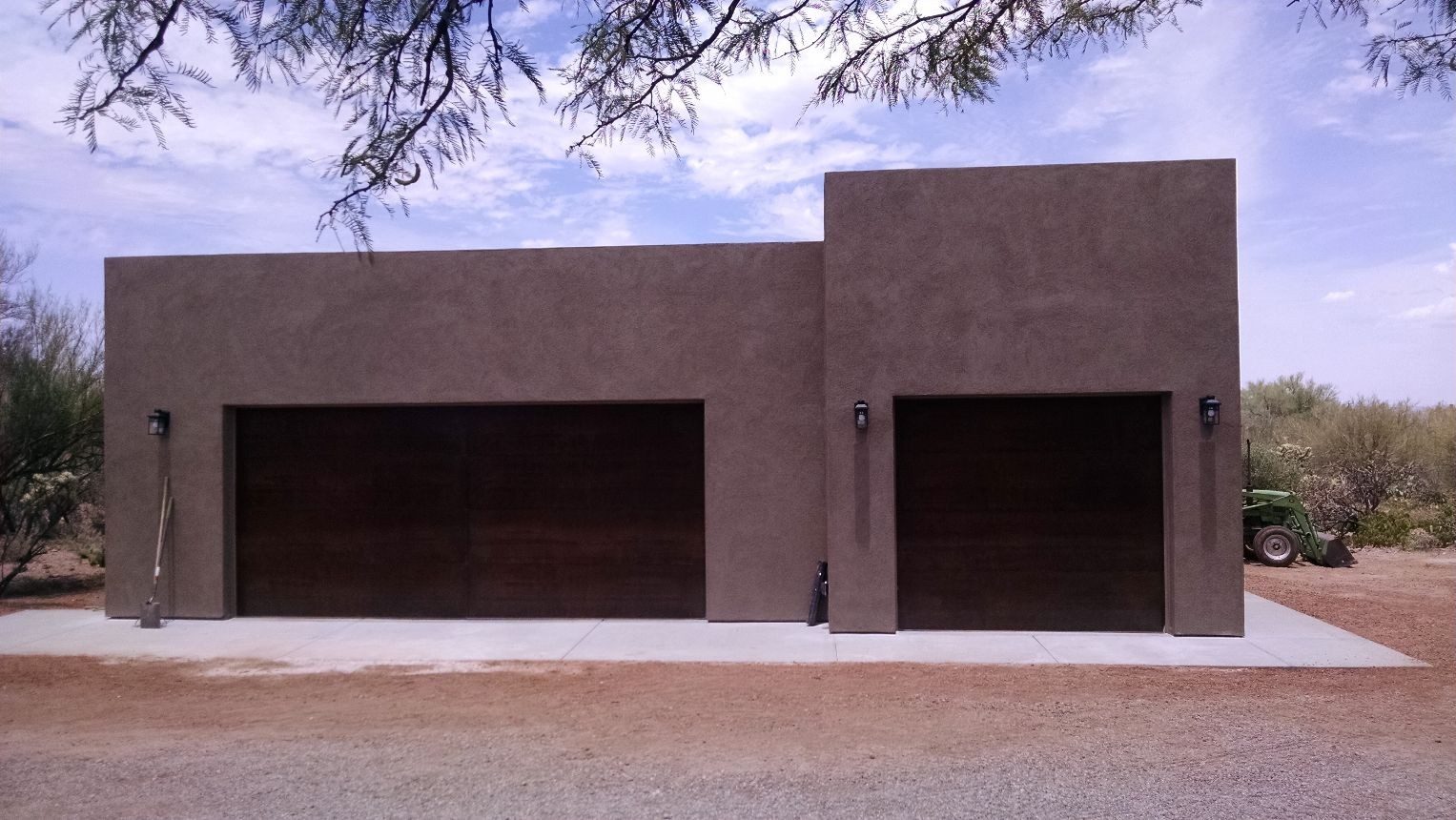 Custom stucco garage with two dark wood-panel doors, built by STM Development in Tucson, AZ